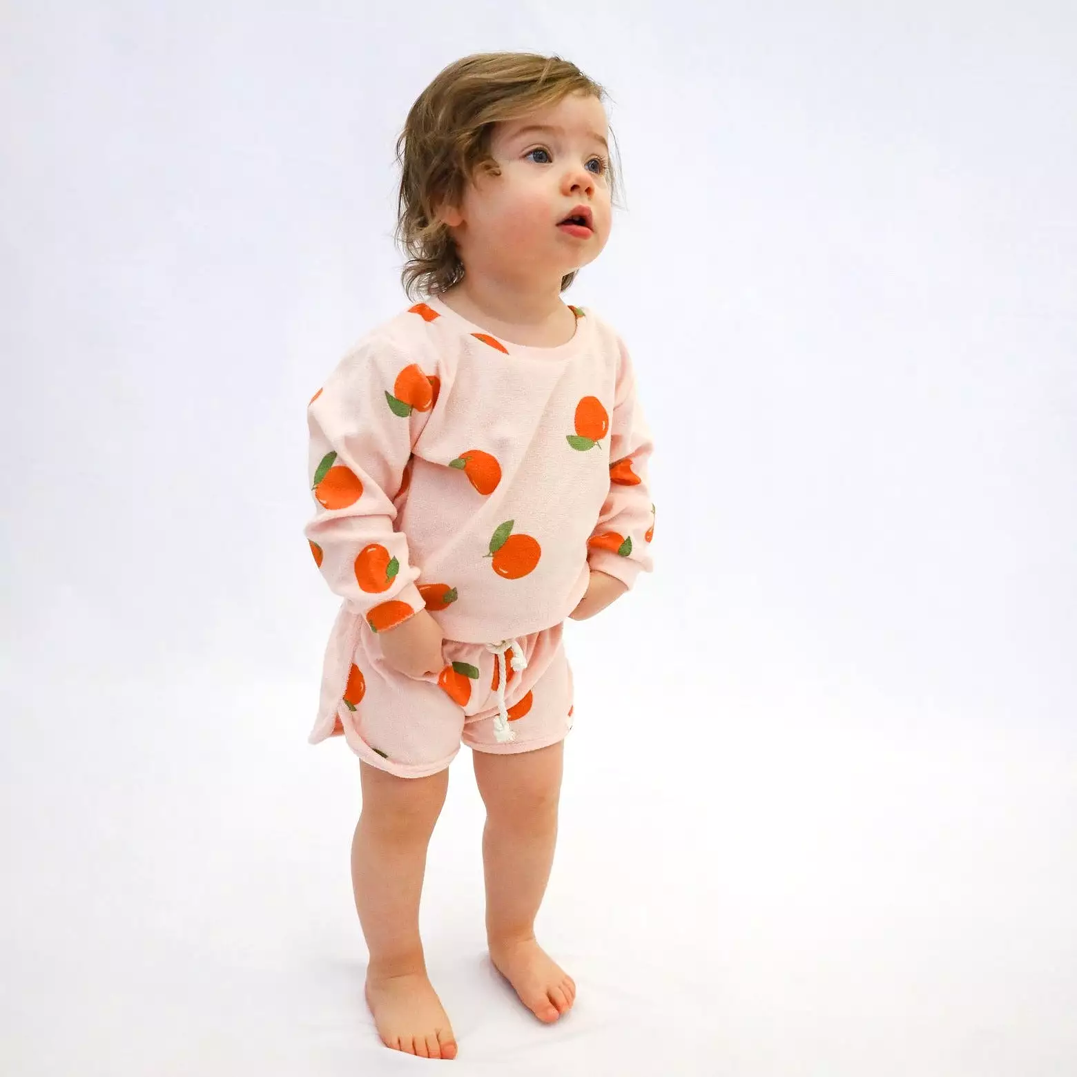 Cotton drawstring track shorts with oranges print in pale pink.