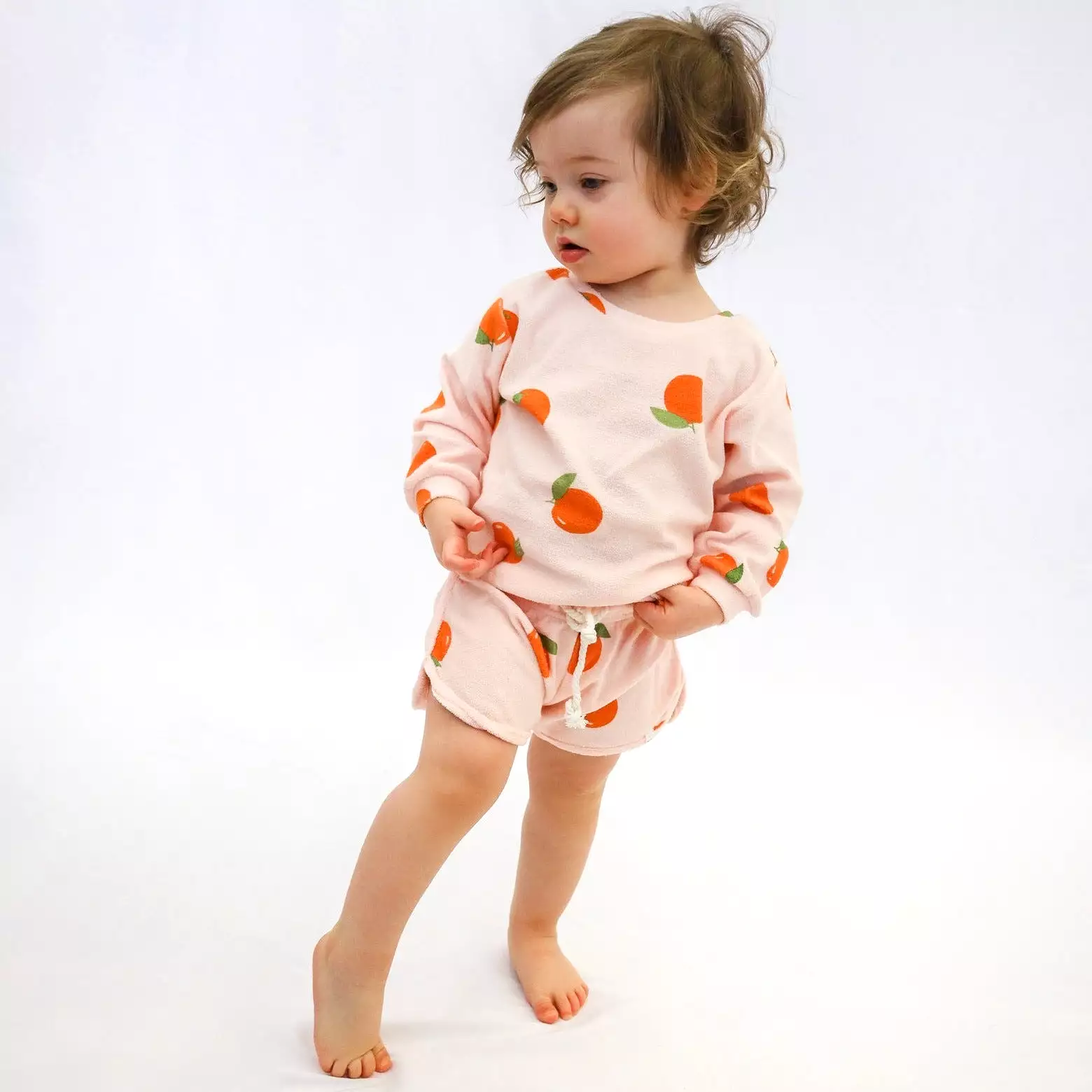 Cotton drawstring track shorts with oranges print in pale pink.