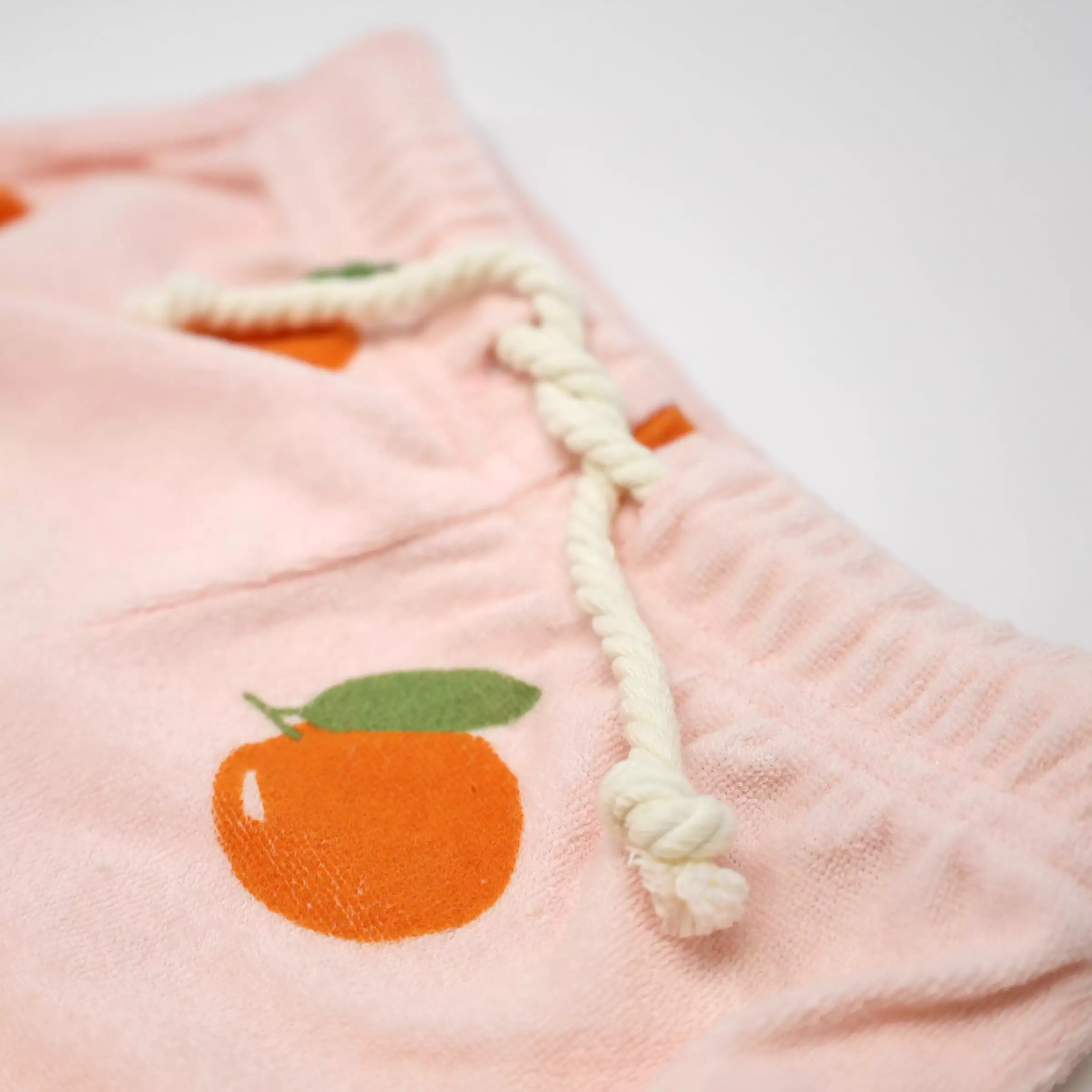 Cotton drawstring track shorts with oranges print in pale pink.